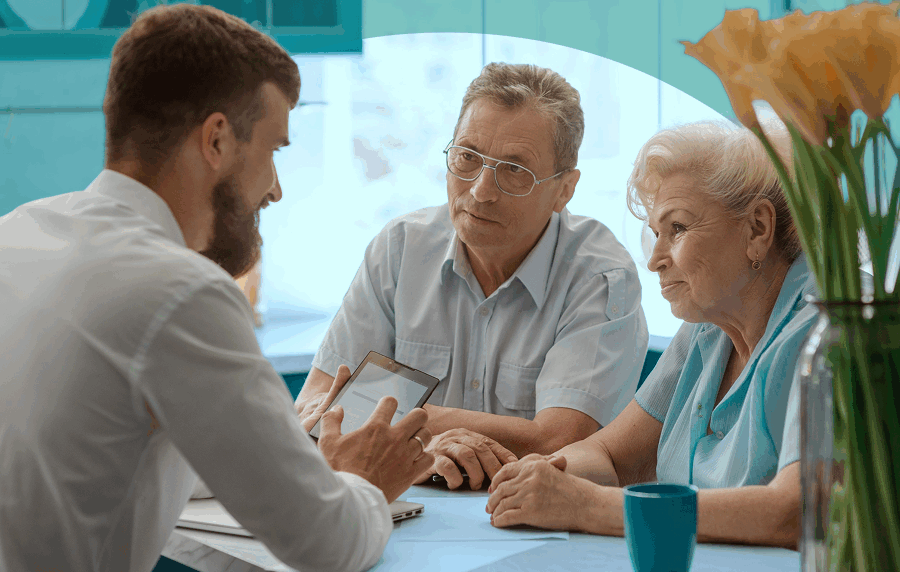 Senior couple sitting across a table from a young male insurance agent