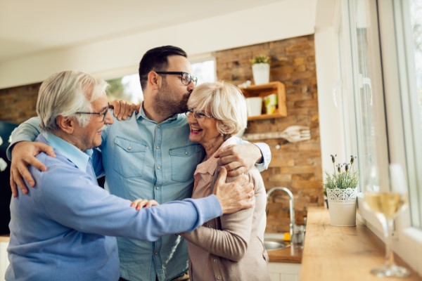 A son embracing his elderly parents