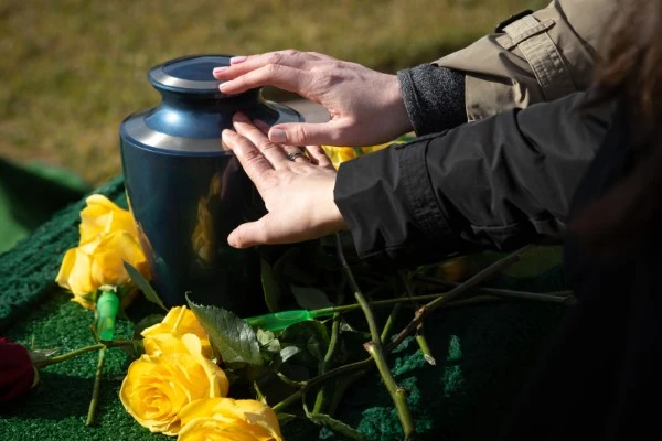 Two people touching an urn