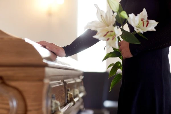 A woman touching a casket