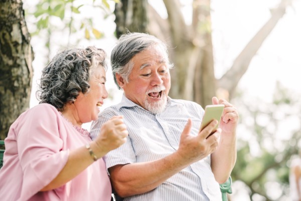 happy senior couple exciting with smartphone