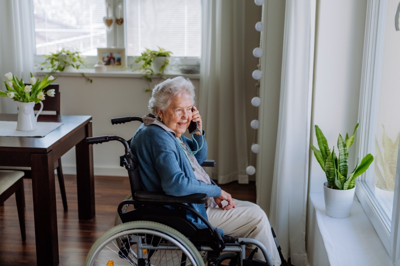Portrait of senior woman with wheelchair on a phone call