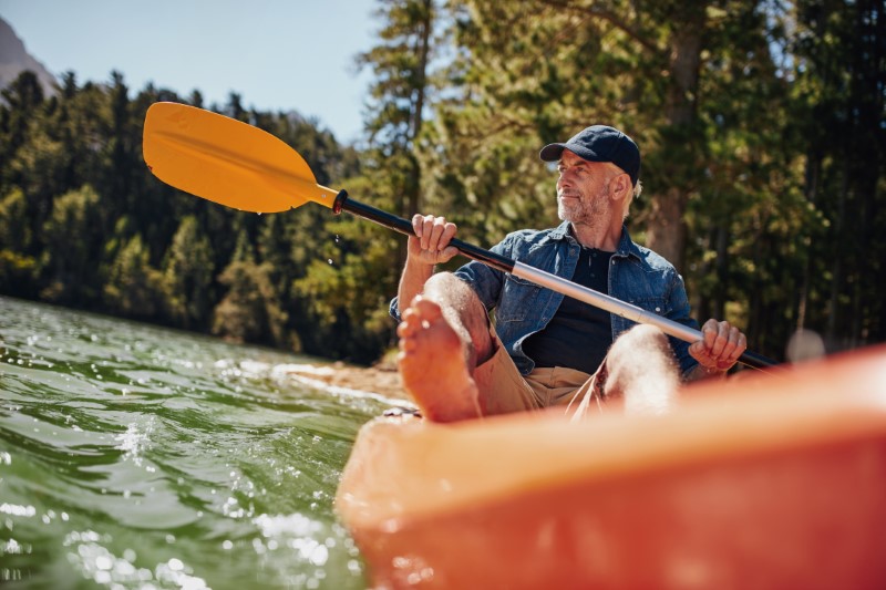 Portrait of a mature man kayaking in a lake, looking into the distance