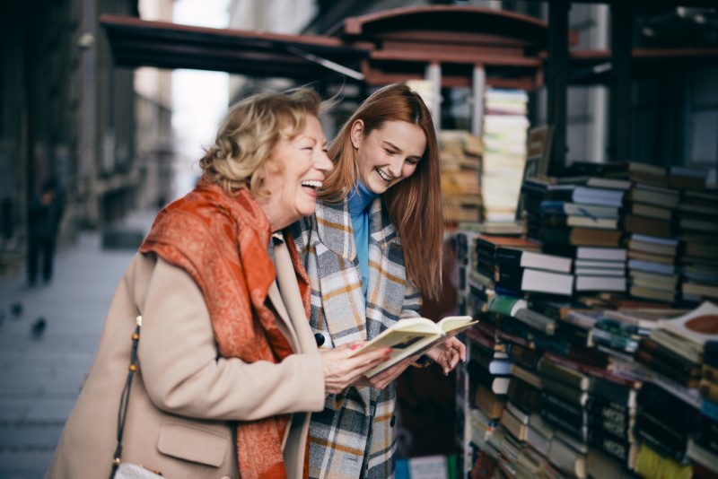 A grandmother and granddaughter choosing books at outdoor bookshop