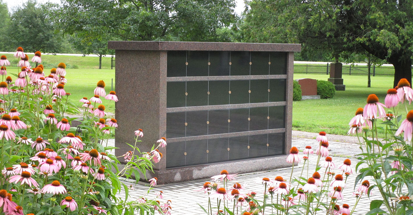 A large columbarium features multiple compartments for remains surrounded by cone flowers.