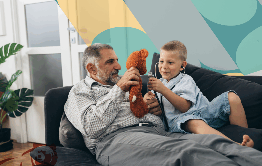 Senior man with medium skin tone holding a stuffed animal, playing on couch with boy who has stethoscope in his ears
