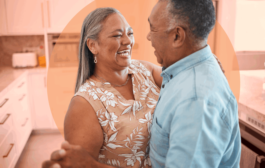 Hispanic couple dancing and smiling in kitchen