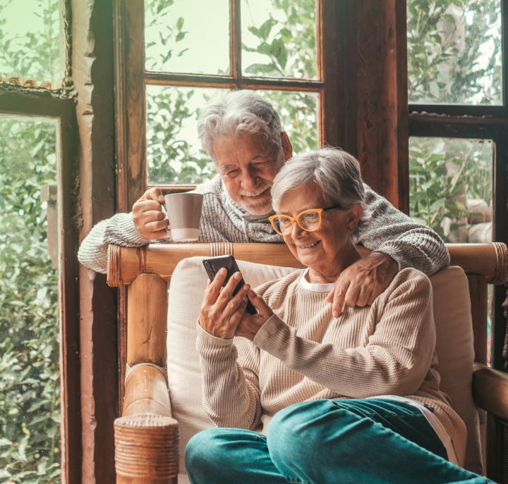 Two older adults looking at a cell phone.