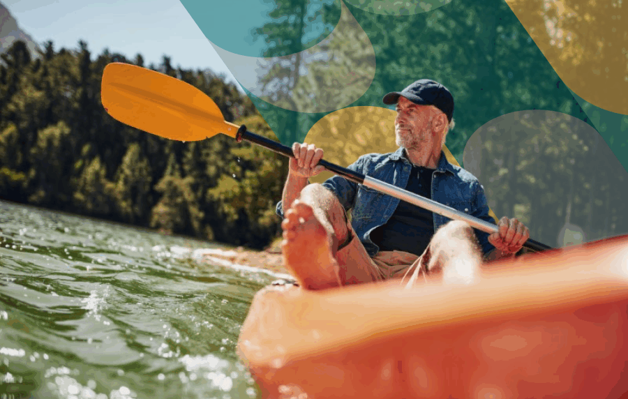 Middle-aged or senior white man in baseball cap canoeing on a river