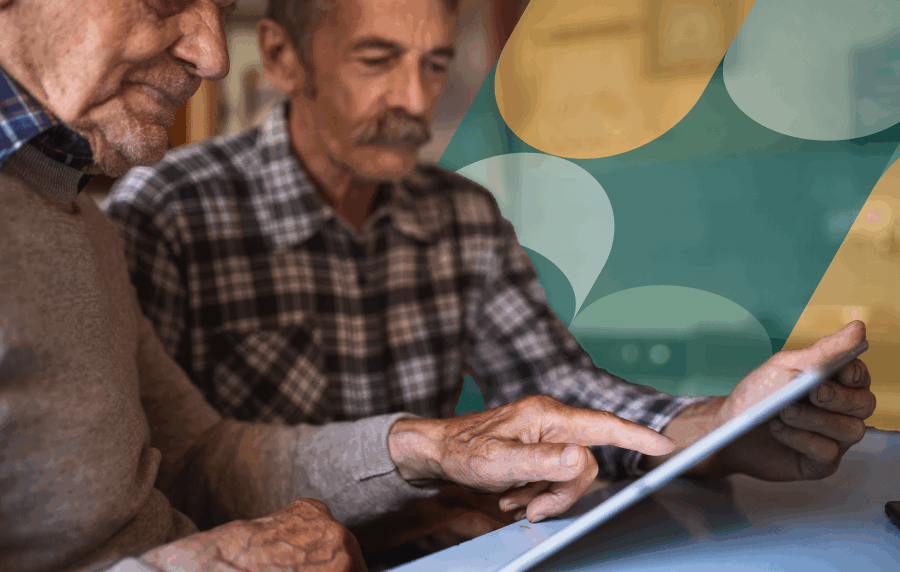 Close-up shot of a middle aged man with a mustache and elderly man in a sweater looking at documents together