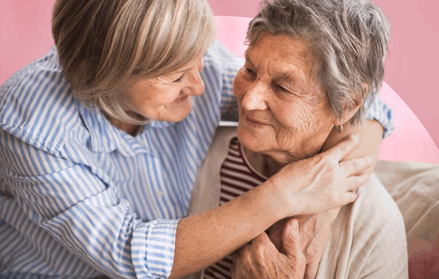 Close-up shot of a middle-aged woman with her arms around an elderly woman