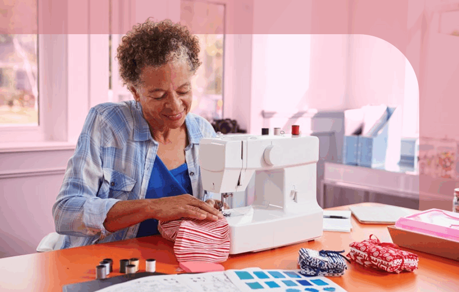 Sernior black woman with short curly hair using a sewing machine