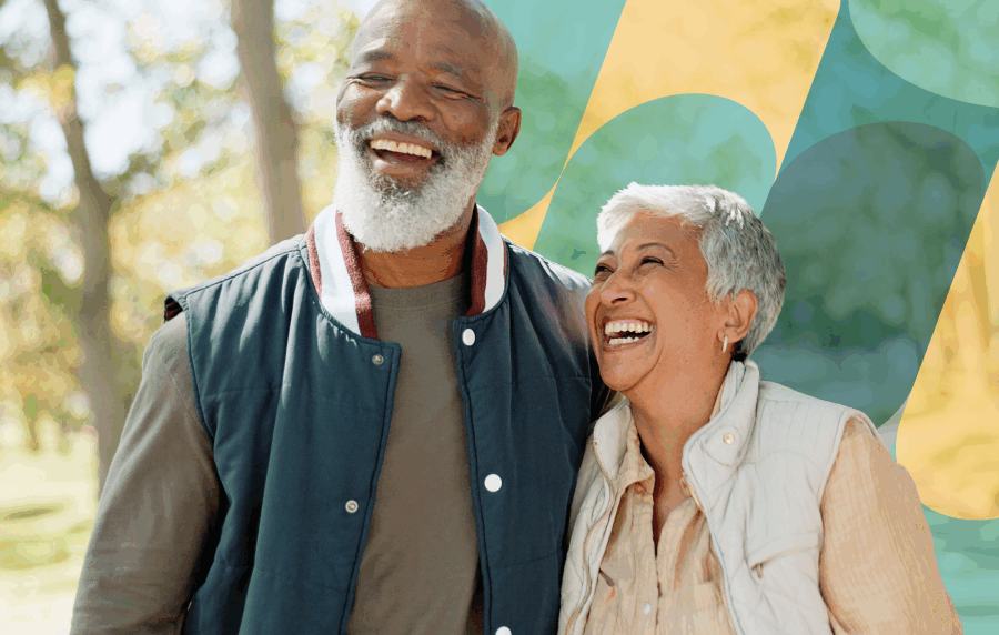 Close-up shot of a senior couple - a Black man with a beard and Hispanic woman with short hair - walking outside and smiling